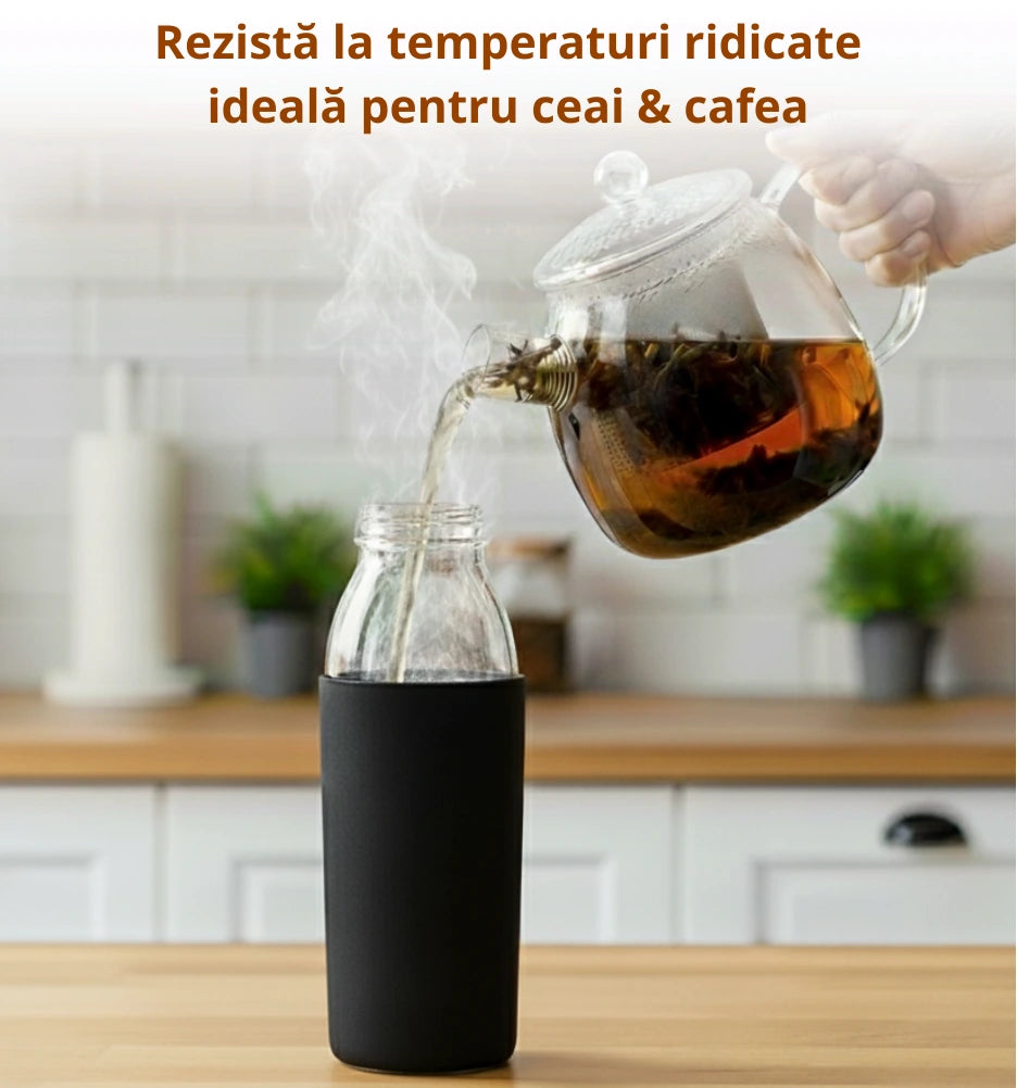 Sticla borosilicata de 500ml care sta pe masa, deschisa, o domnisoara toarna ceai fierbinte din ceainic in sticla. Sticla rezista la temperaturi ridicata, ideala pentru ceai si cafea.