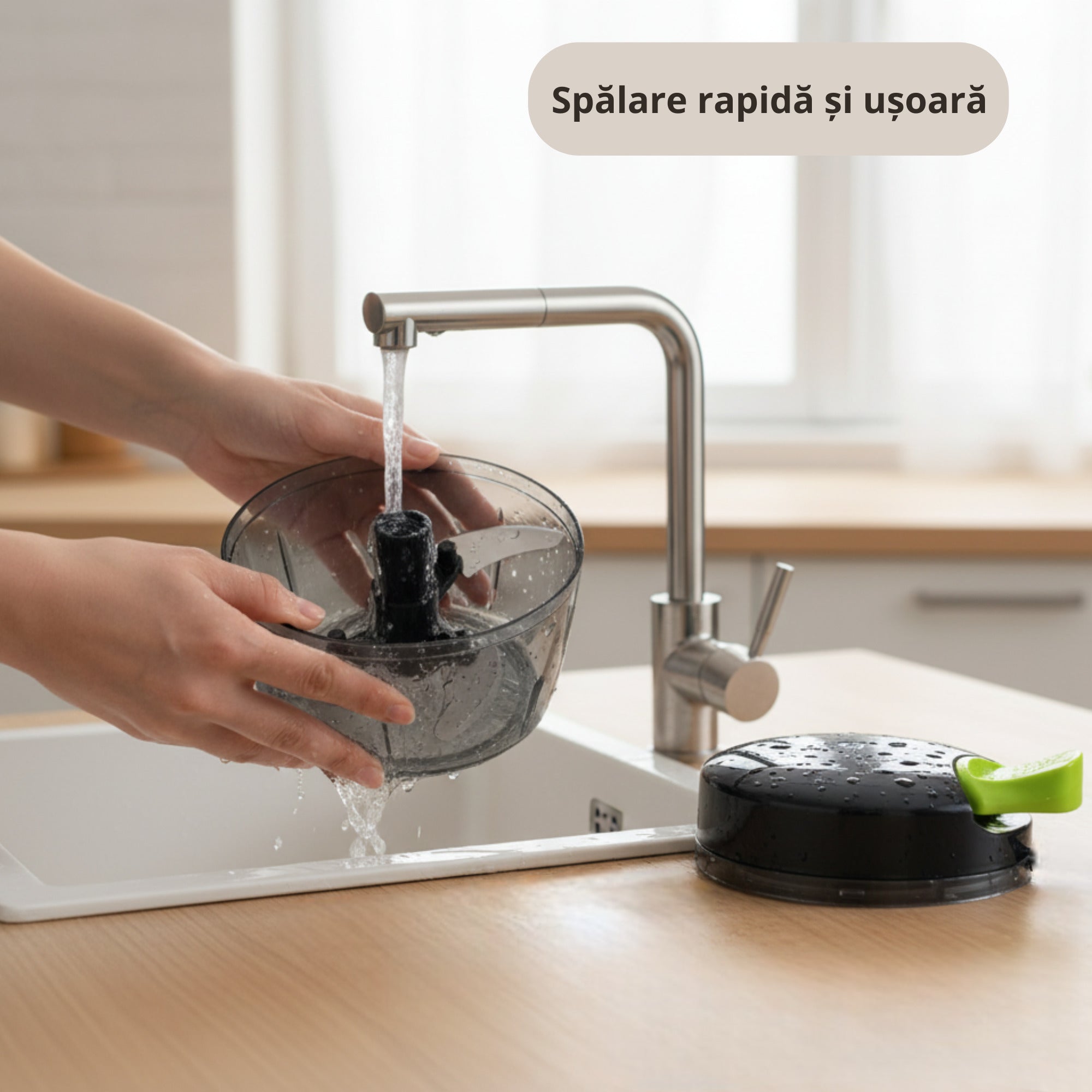 Persoana spala sub jet de apa un tocator manual Koken din plastic transparent cu lame metalice, in timp ce capacul cu maner verde este asezat pe blatul din bucatarie.