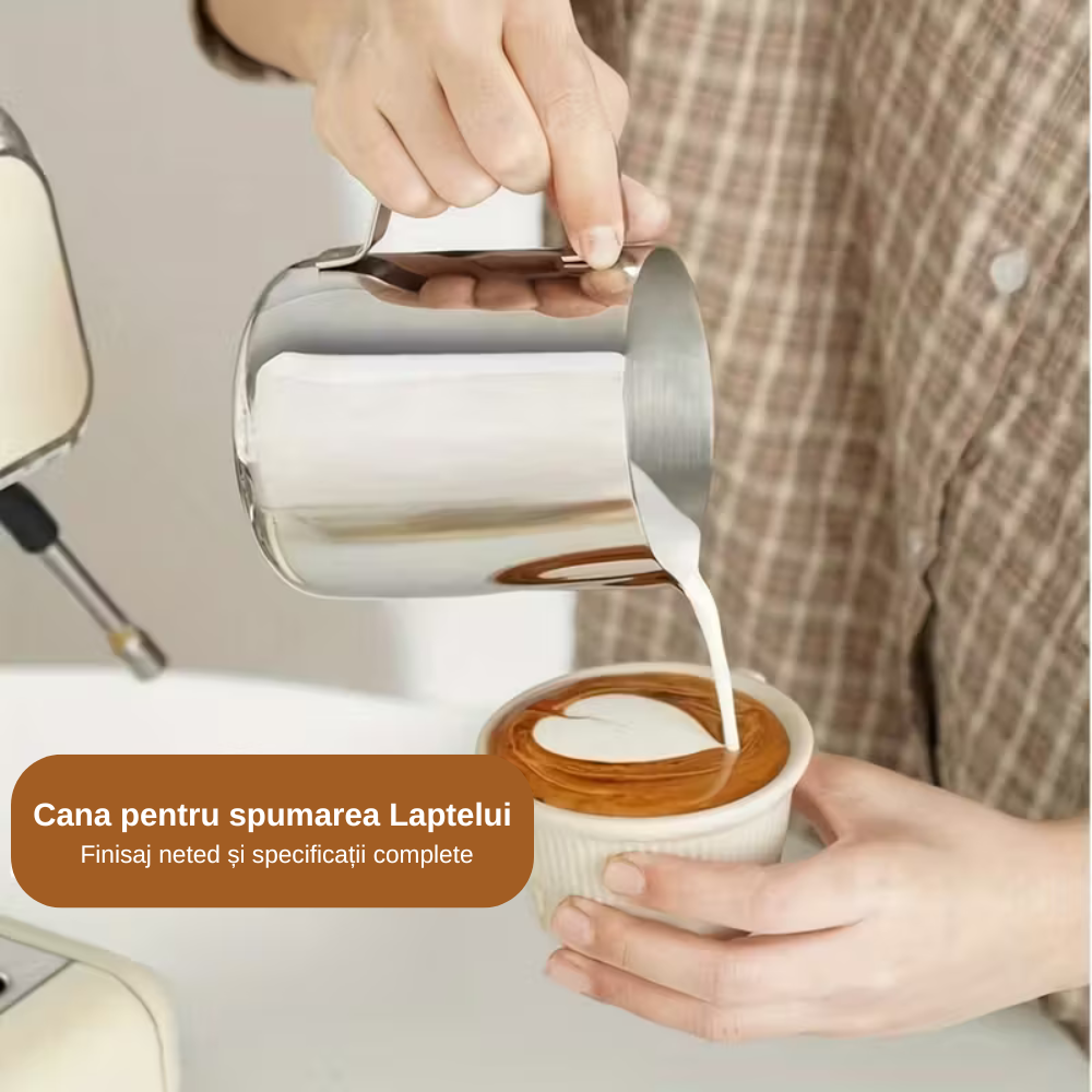 In poza este aratat O Mână turnând lapte spumat din cana de inox de 900 ml pentru a crea un model de inimă (Latte Art) într-o ceașcă de cafea