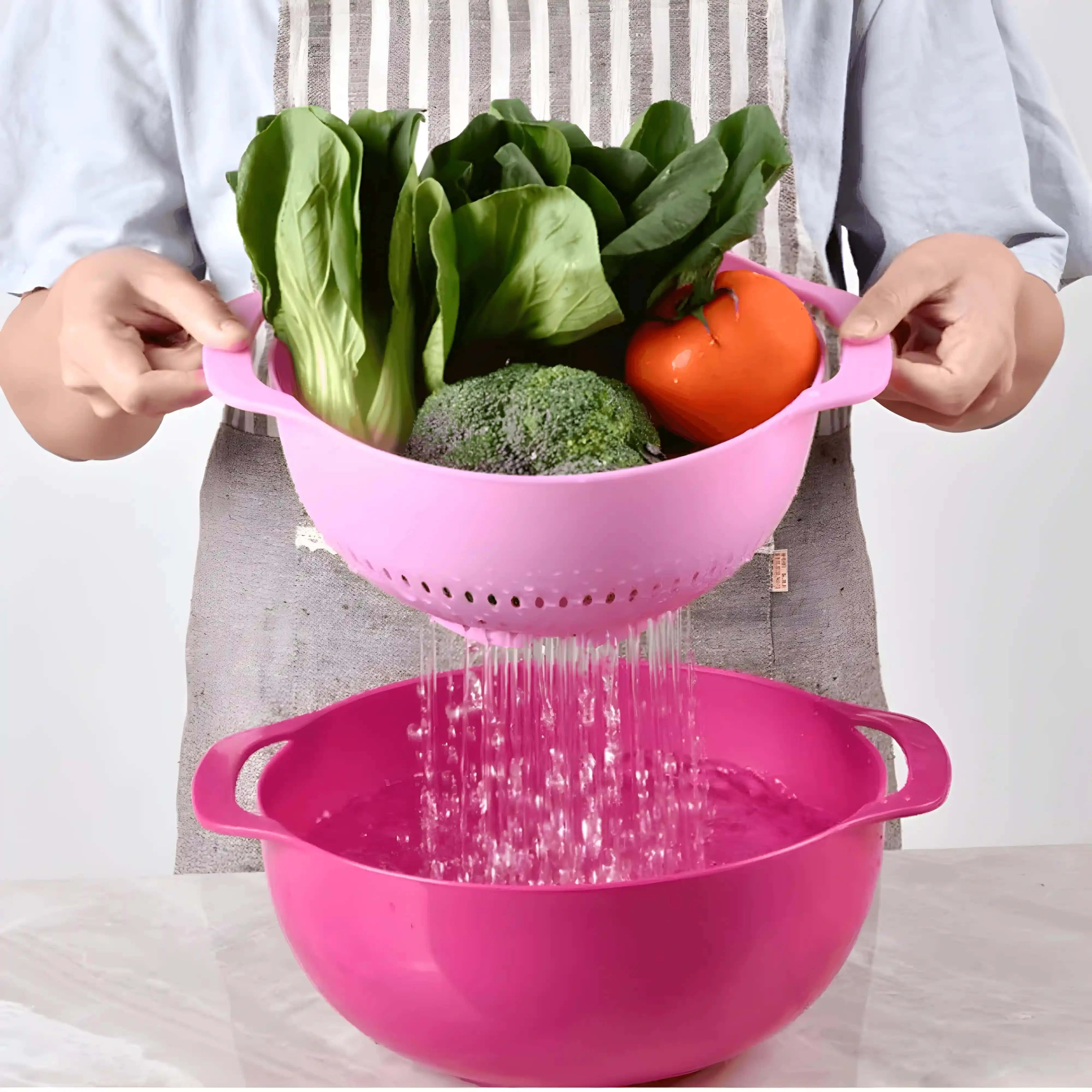 Imagine care prezintă un bol cu sită folosit pentru scurgerea apei după spălarea legumelor, inclusiv salată verde, broccoli și roșii.